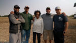 The western family standing outside their farm.