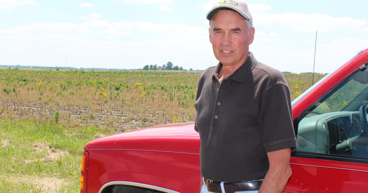 portrait of Jack Erisman standing in front of a red pickup truck wearing a ballcap